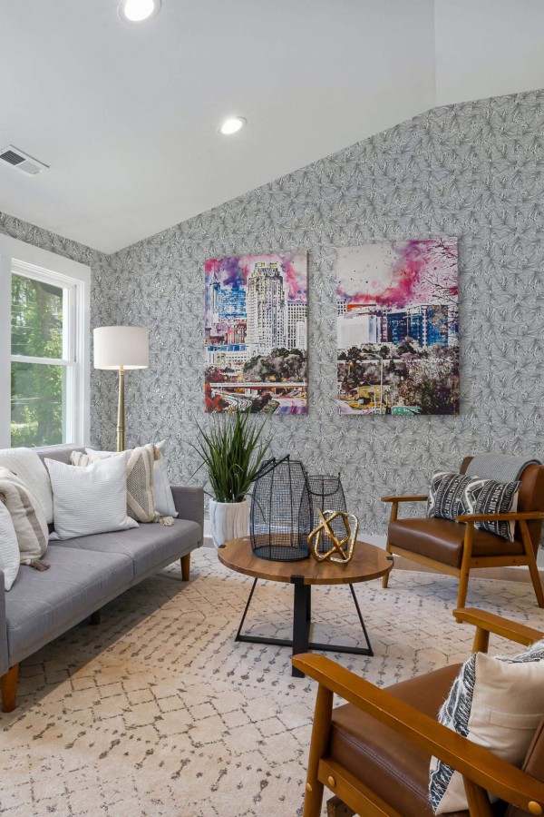 Mid-century modern style living room decorated with Monstera leaf peel and stick wallpaper and colorful funky artwork
