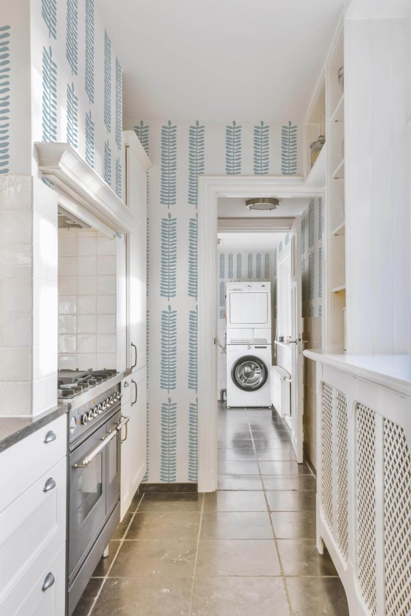 Minimal farmhouse style laundry room decorated with Scandinavian leaf peel and stick wallpaper