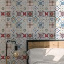 Portuguese Tile wallpaper with multicolor vintage-style tile pattern, styled in a sunlit bedroom with wood bedframe and modern lamp.