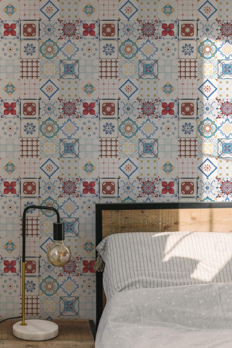 Portuguese Tile wallpaper with multicolor vintage-style tile pattern, styled in a sunlit bedroom with wood bedframe and modern lamp.