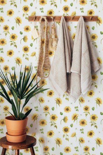 Sunflower peel and stick wallpaper in botanical bathroom with wooden towel rack and terracotta potted plant