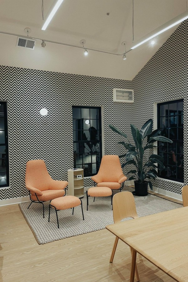 Minimal style living room decorated with Zig zag peel and stick wallpaper and mid-century style chairs
