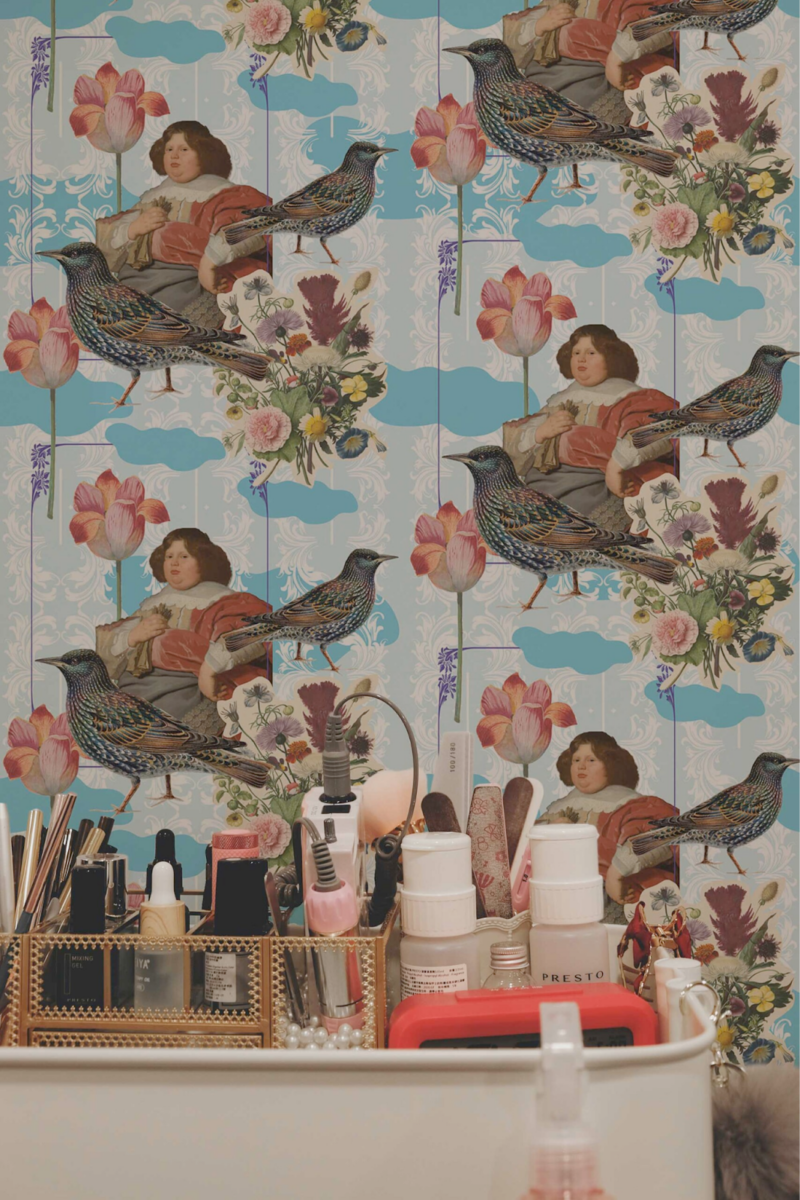 Whimsical blue chateau peel and stick wallpaper with vintage collage art in a playful vanity corner
