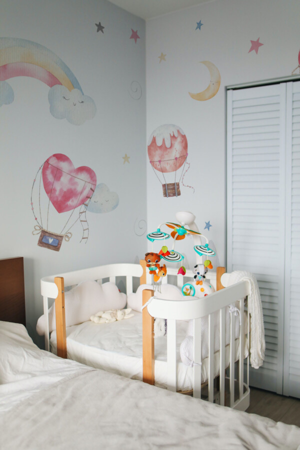 Nursery Watercolor Skies Wall Mural with pastel mountains, fluffy clouds, and heart-shaped balloons, perfect for dreamy nursery interiors.