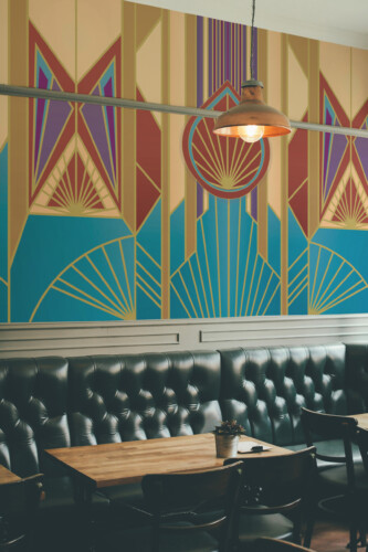 Fancy Walls Art Deco Burst wall mural showcasing radiant patterns in red, gold, blue, and purple hues.