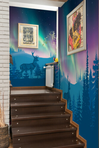 Fancy Walls Majestic Northern Lights Deer wall mural with glowing blue aurora and tree silhouettes.