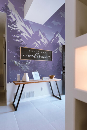 Fancy Walls Winter Calmy Forest wall mural showing graphic mountain peaks and falling snow.