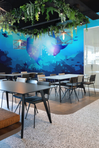 Fancy Walls Underwater Shark Dance peel and stick wall mural with swimming sharks and glowing ocean light.