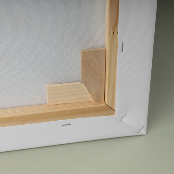 Back of a custom canvas print showing wooden frame with adjustable corner wedges