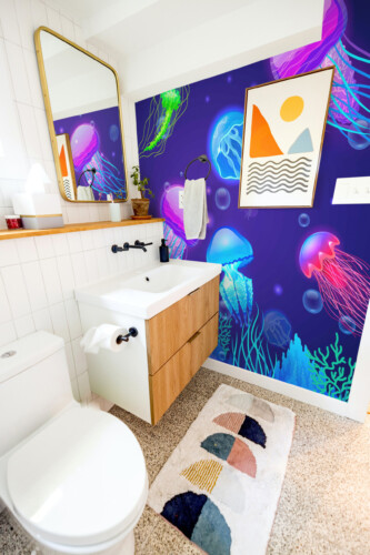 Fancy Walls printed wall mural Neon Jellyfish Dance highlighting glowing aquatic movement in blue and pink hues.