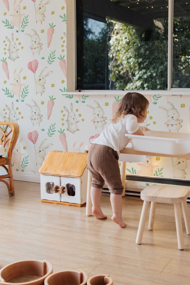 Fancy Walls self-adhesive wallpaper with pastel watercolor bunnies and greenery to create a calming woodland-inspired baby room.