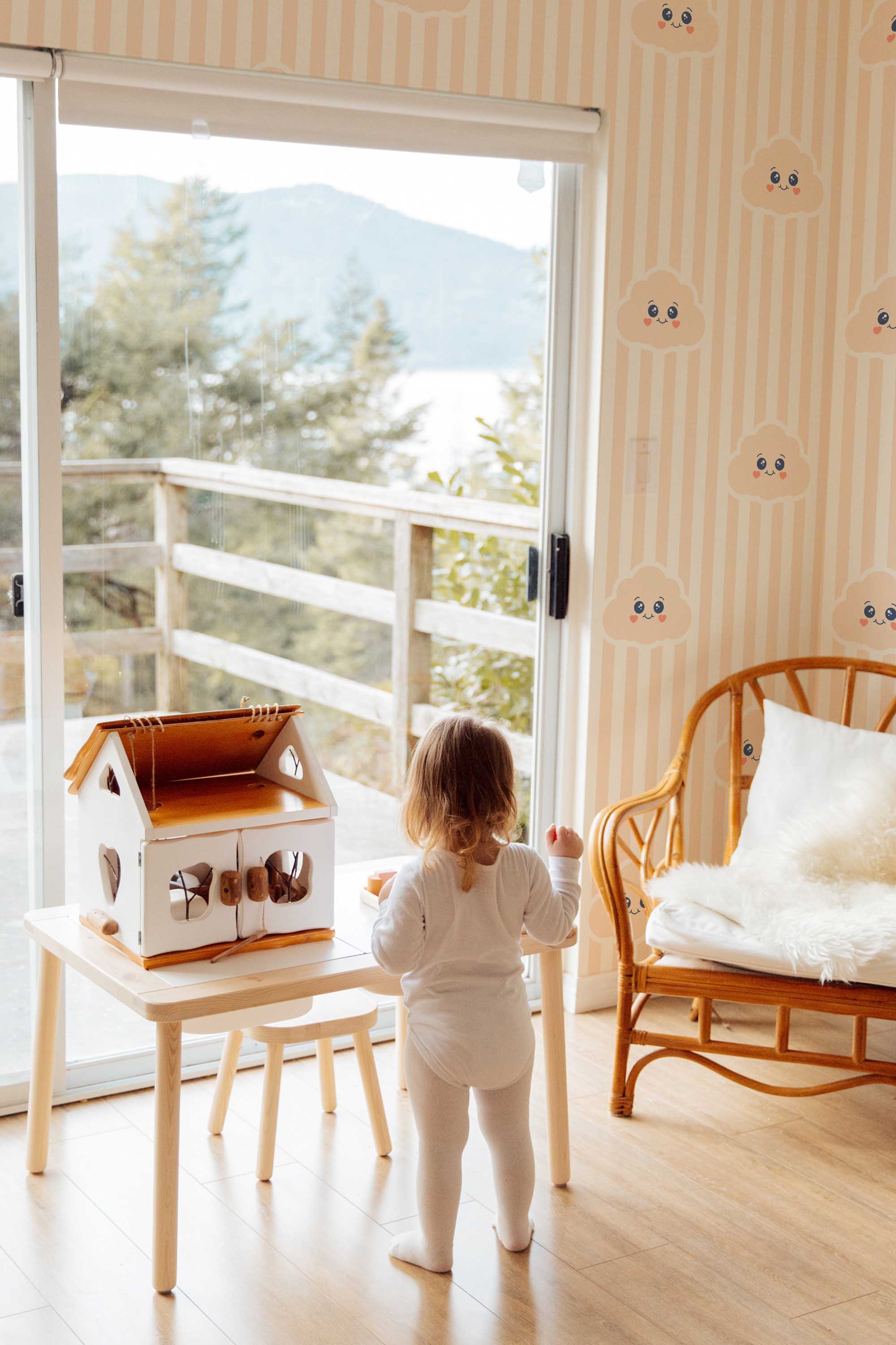 Fancy Walls self-adhesive wallpaper featuring peach cloud motifs and beige stripes ideal for a gentle modern nursery look.