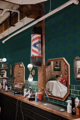 Fancy Walls self-adhesive wallpaper featuring classic blue star motifs over green for timeless nautical interiors.