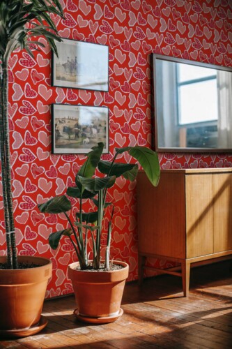 Fancy Walls peel and stick wallpaper with layered red paper hearts creating a handmade romantic accent wall.