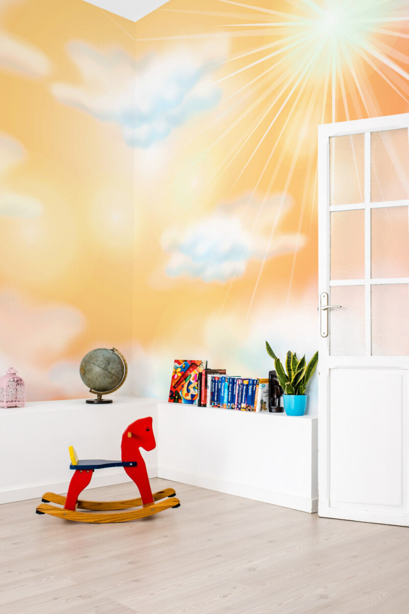 Fancy Walls sunny sky glow wall mural with pastel clouds and radiant sun rays