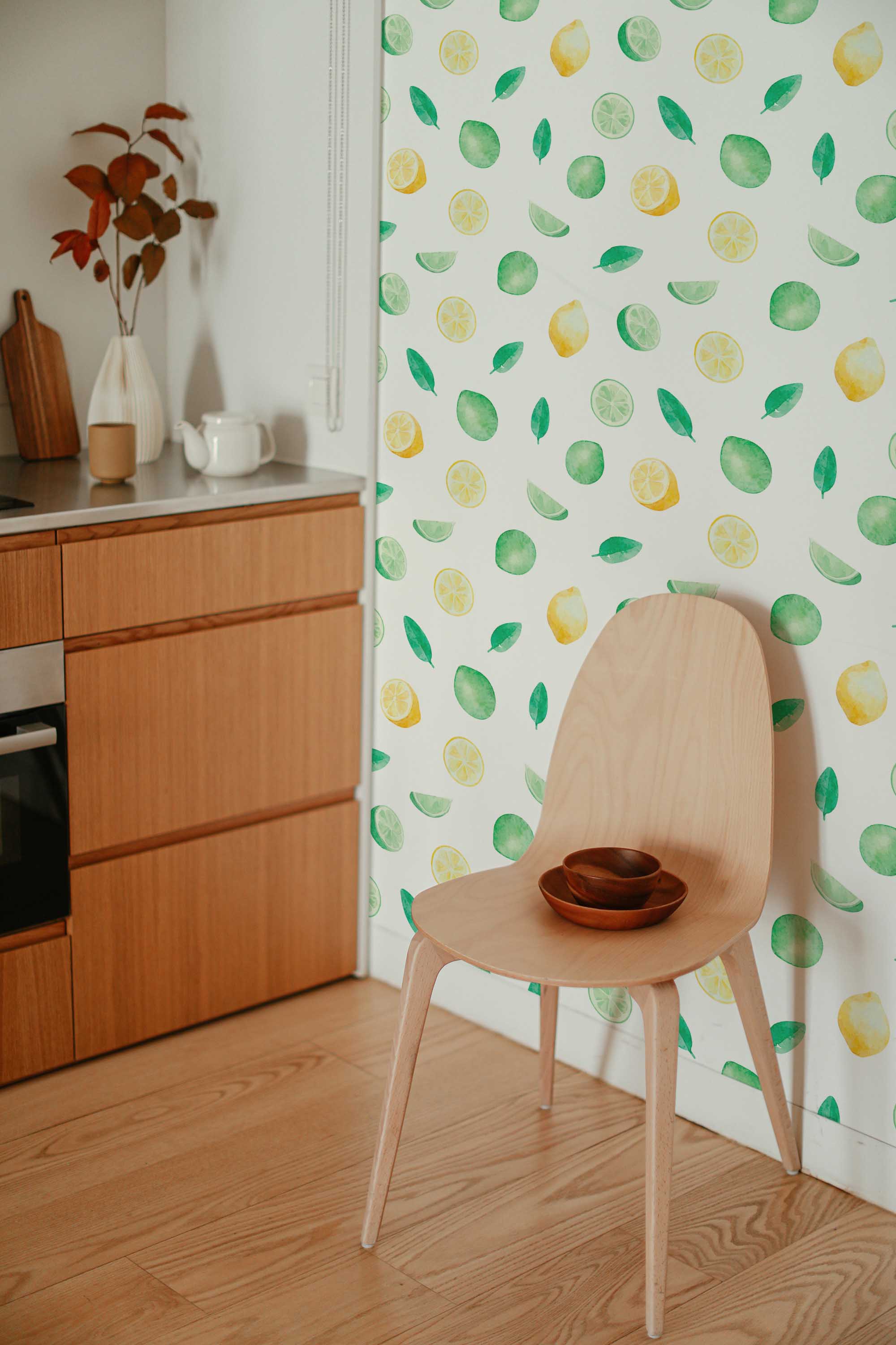 Fancy Walls self-adhesive wallpaper featuring vibrant citrus fruits and green leaves on a crisp white background.