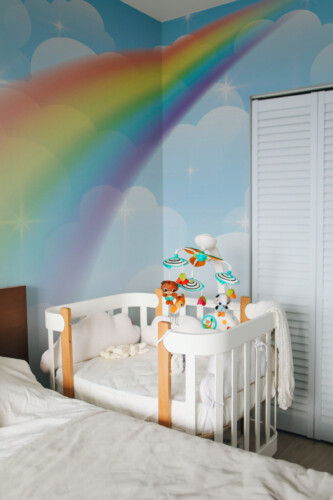 Fancy Walls peel and stick wall mural with pastel rainbow and soft clouds for dreamy nursery and kids room décor in modern Scandinavian style.