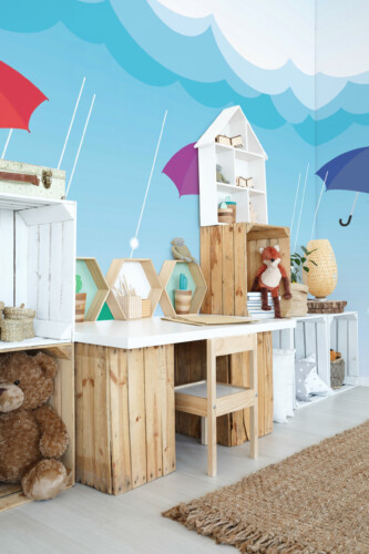 Fancy Walls peel and stick PVC-free wall mural with colorful floating umbrellas on blue rainy sky for modern kids room décor and playful nursery spaces.