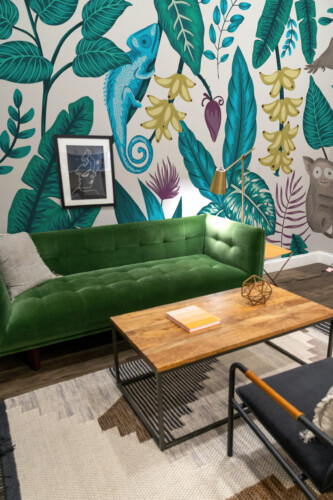 Fancy Walls Jungle Wildlife removable wall mural with tropical plants, monkey, birds, and chameleon creating colorful jungle décor.