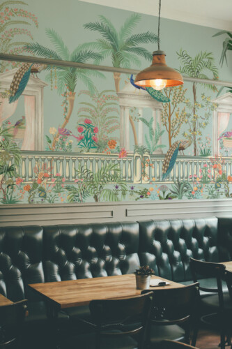 Fancy Walls traditional non-pasted eco-friendly wall mural featuring vintage peacock terrace scene with palms and florals for bedrooms and dining spaces.