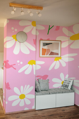Fancy Walls Spring Bunny Meadow peel and stick PVC-free wall mural with bunny silhouettes and daisies on pink background for nursery and kids room décor.
