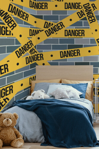 Urban Danger Zone peel and stick wall mural with yellow danger tape over brick wall, creating edgy décor for boys and gaming room