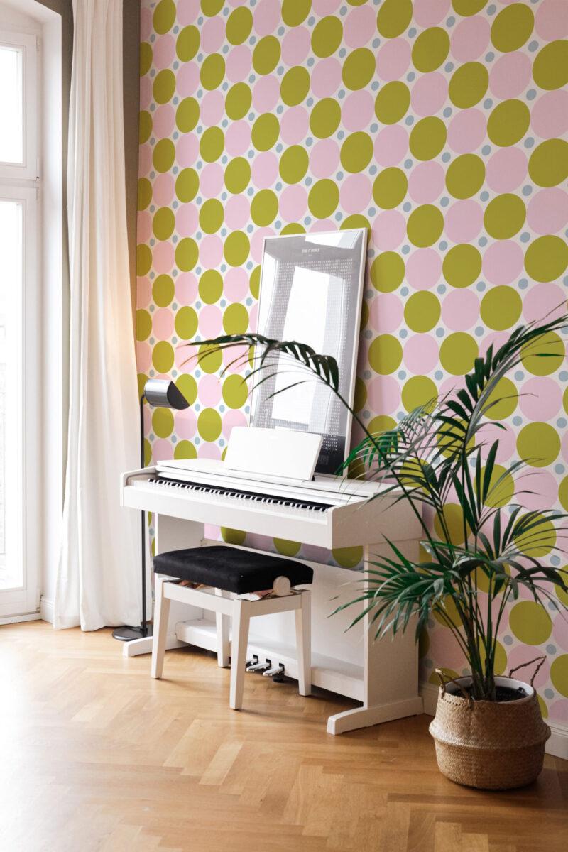 Bold Green Retro Polka Dot peel and stick wallpaper covering an accent wall behind a white piano in a bright room.