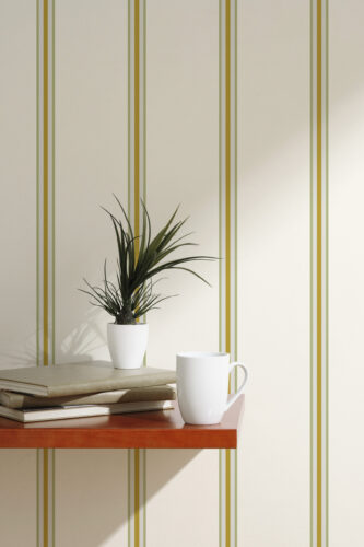 Fine Beige Striped peel and stick wallpaper with thin olive and ochre vertical lines behind a small shelf.