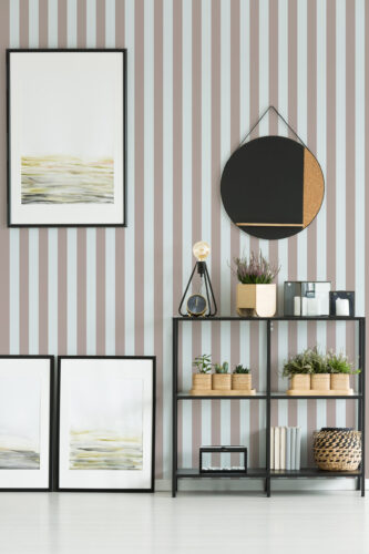 Taupe Blue Vintage Stripe removable wallpaper with wide vertical taupe and pale blue stripes behind a shelving unit.