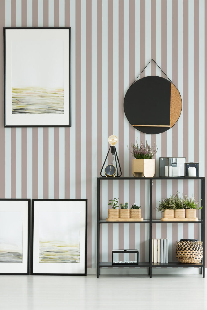 Taupe Blue Vintage Stripe removable wallpaper with wide vertical taupe and pale blue stripes behind a shelving unit.