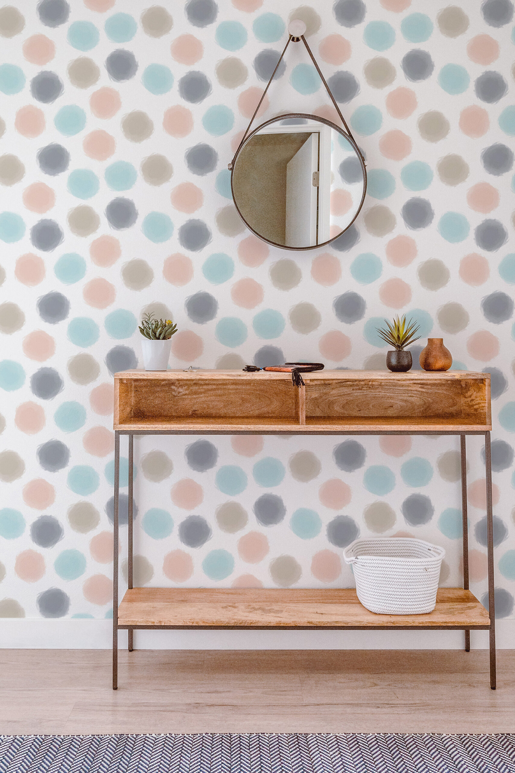 Spaced Beige Dots pre-pasted wallpaper with pastel polka dots behind a narrow console table and a round hanging mirror.