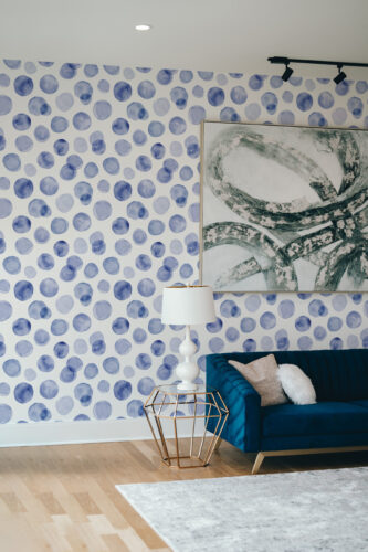 Soft Blue Dots peel and stick wallpaper covering a full accent wall with watercolor-style blue circles in varied tones.