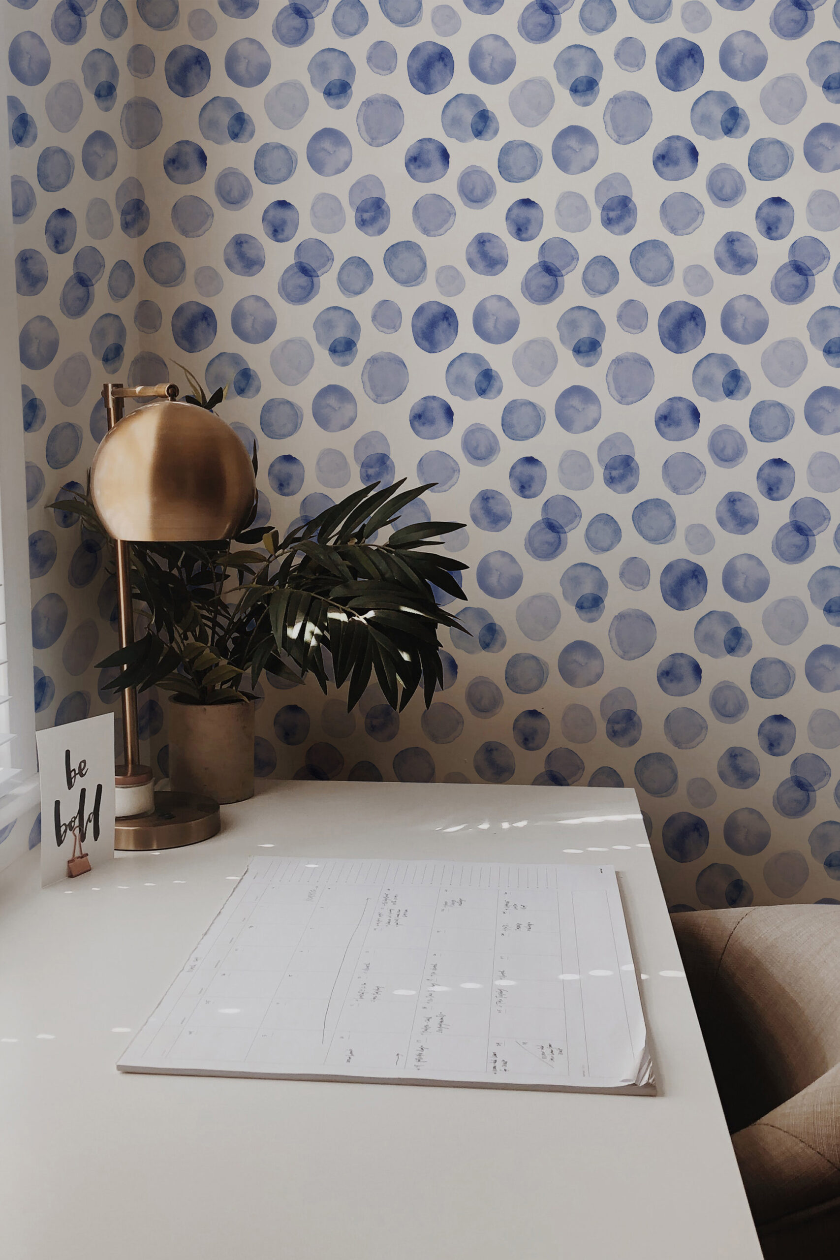 Soft Blue Dots non-pasted wallpaper with watercolor blue circles covering the wall behind a desk.