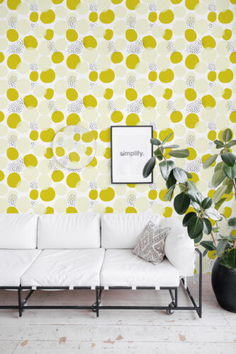 Bold Chartreuse Polka Dot peel and stick wallpaper in a living room, covering the wall behind a white sofa with layered dots.