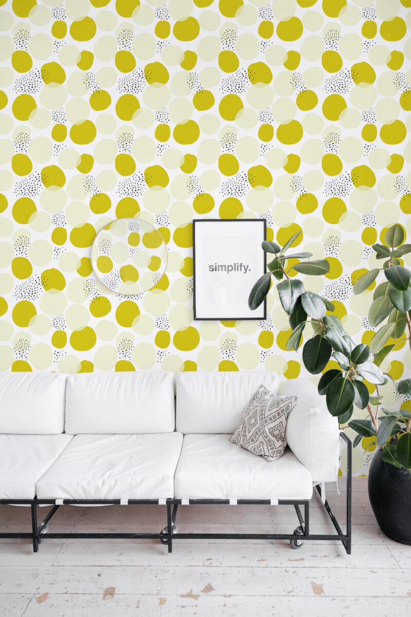 Bold Chartreuse Polka Dot peel and stick wallpaper in a living room, covering the wall behind a white sofa with layered dots.