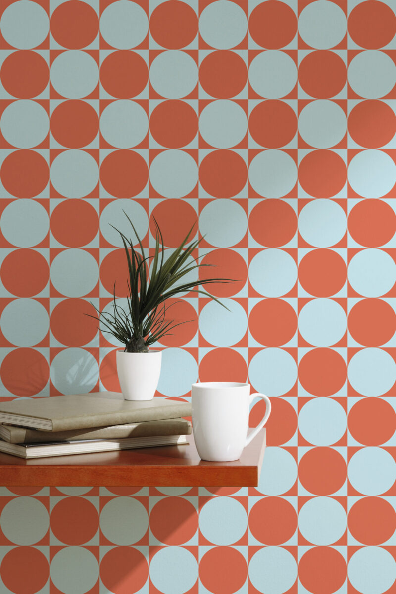 Orange Blue Retro Circles with alternating orange and pale blue circles, shown as peel and stick wallpaper behind a small table.