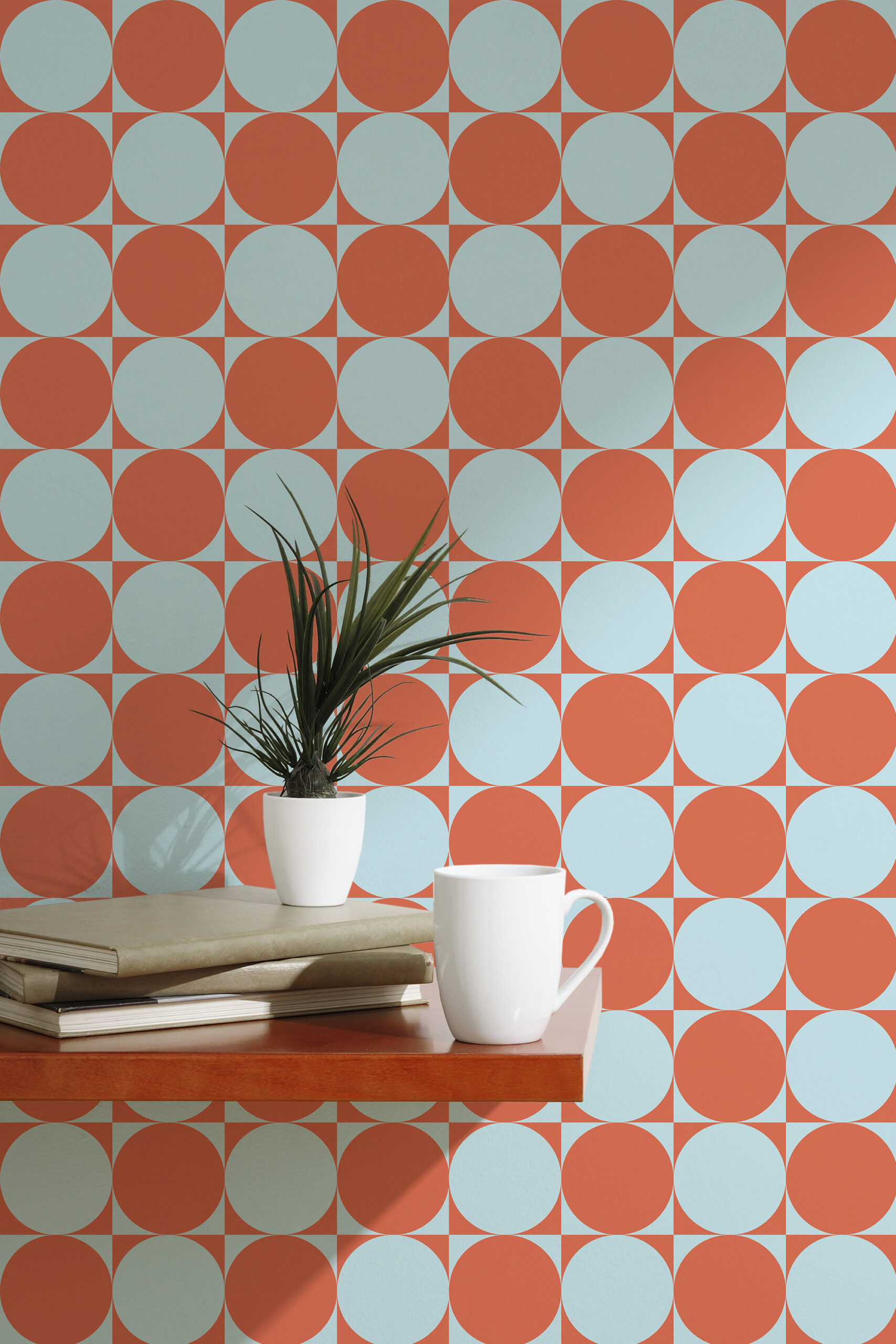 Orange Blue Retro Circles with alternating orange and pale blue circles, shown as peel and stick wallpaper behind a small table.