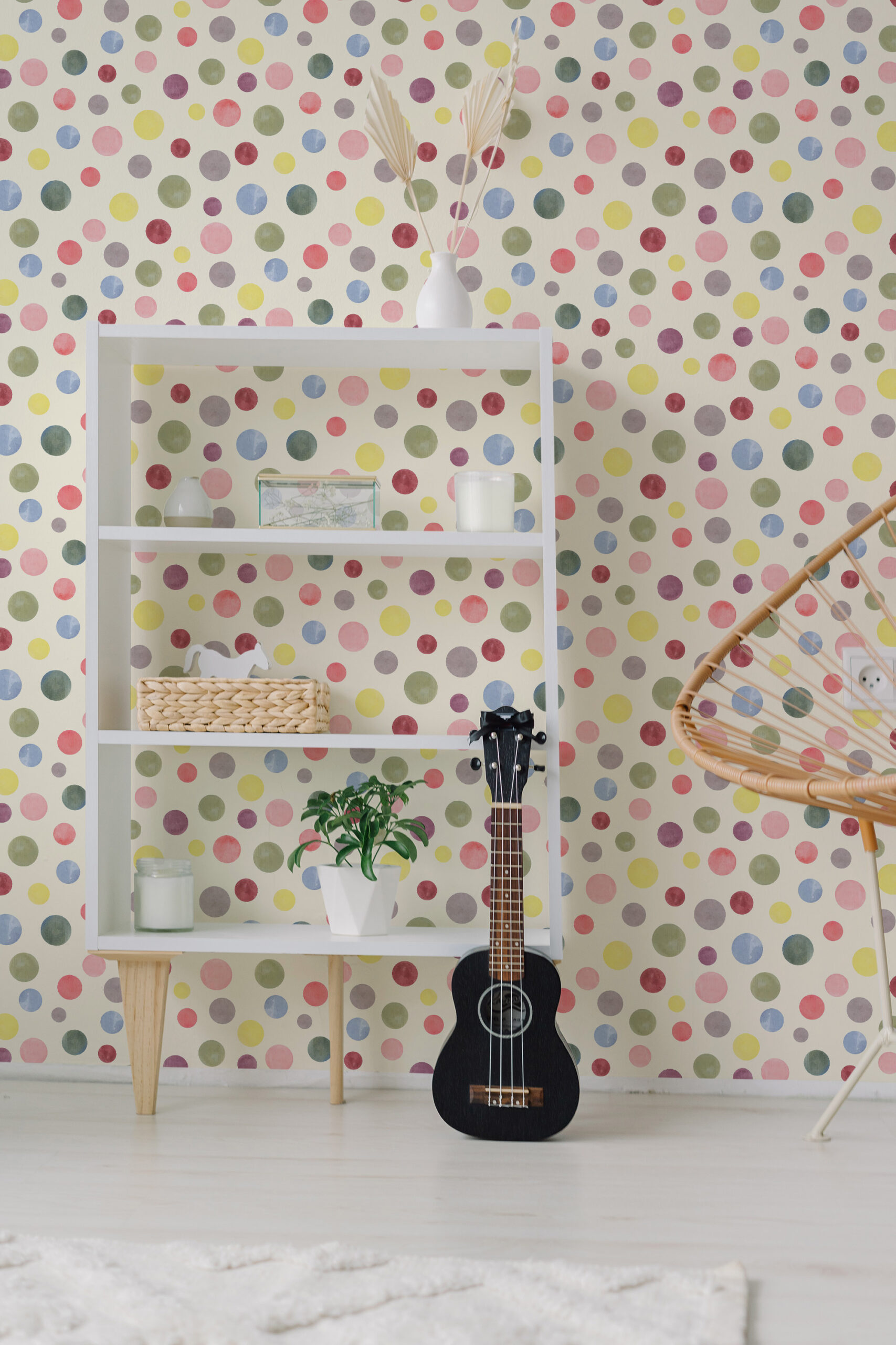 Watercolor Cream Polka Dot self-adhesive wallpaper in soft pastel dots, covering the wall behind a white shelving unit.