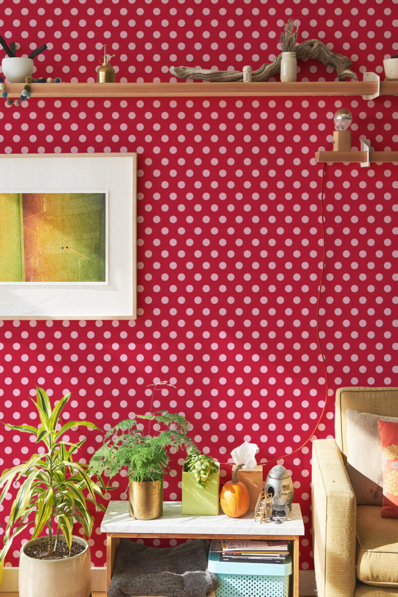 Red Retro Polka Dot peel and stick wallpaper with pink dots across a red wall behind floating shelves and decor.