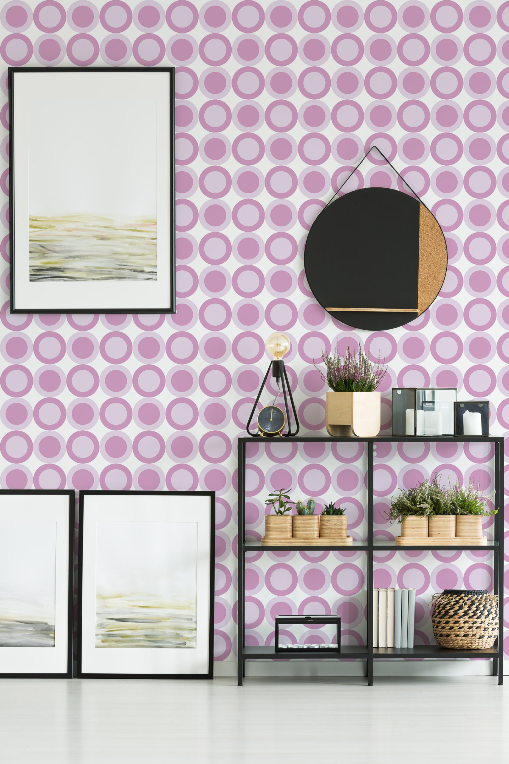 Pink Retro Targets self-adhesive wallpaper with rows of pink concentric circles across the wall behind framed art and shelving.