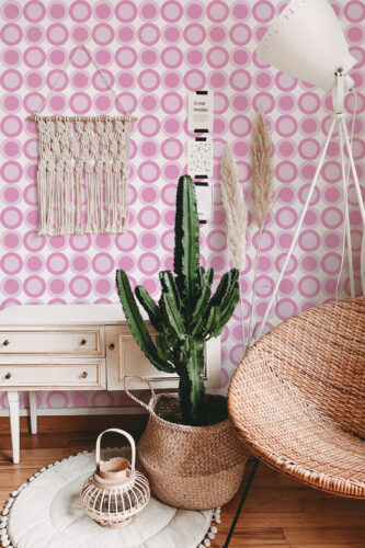Pink Retro Targets peel and stick wallpaper covers the wall in repeating pink and white bullseye circles behind decor.