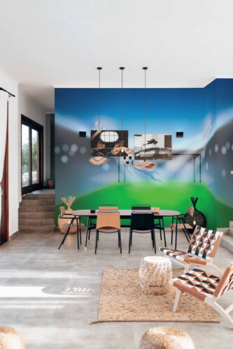 Dynamic Soccer Goal mural wallpaper spans the dining room wall with a goalkeeper dive, net, and soccer ball on a field.