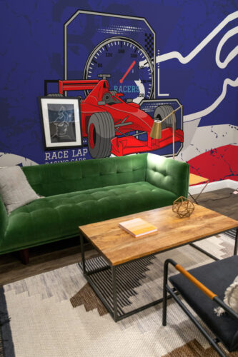 Le Mans Racing Car wall mural covering the living room wall with a red race car and speedometer graphic behind the sofa.