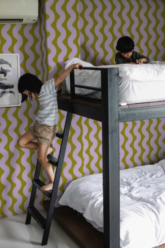 Fancy Walls Wavy Teen Room wallpaper for walls with colorful retro wave lines for playful spaces