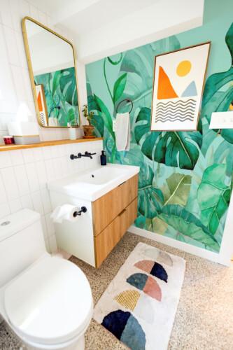 Tropical Green Oasis peel and stick wall mural with watercolor jungle leaves and hidden reptiles, perfect for living room décor