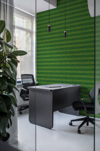 Dense Green Grass look at non-pasted wallpaper with alternating green stripes on an office accent wall behind a desk.