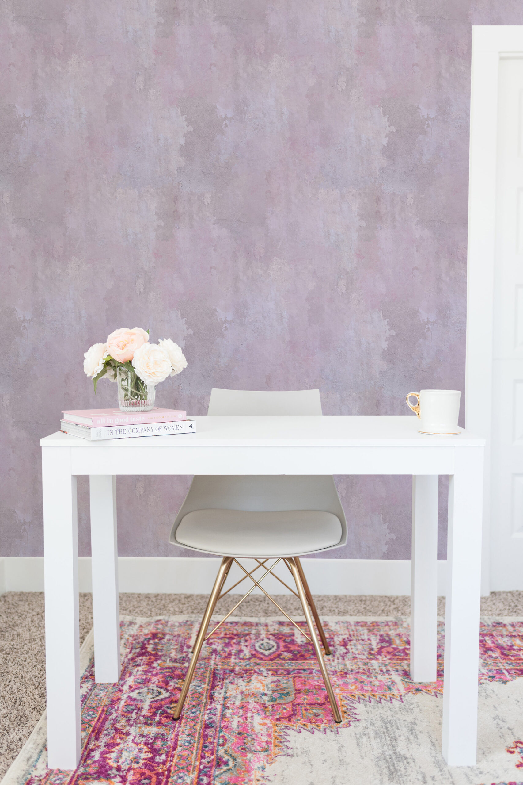 Cloudy Pink Plaster Look self-adhesive wallpaper behind a white desk, with a soft mottled pink and gray finish.