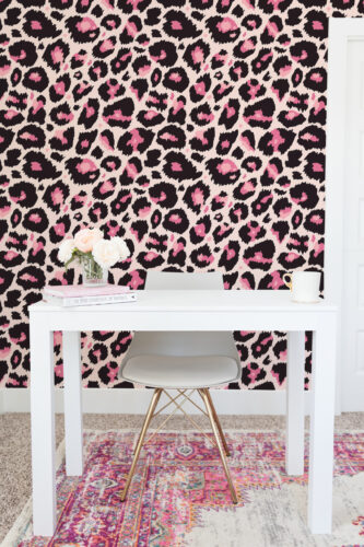 Bold Pink Leopard non-pasted wallpaper with black and pink leopard spots covering a wall behind a white desk.