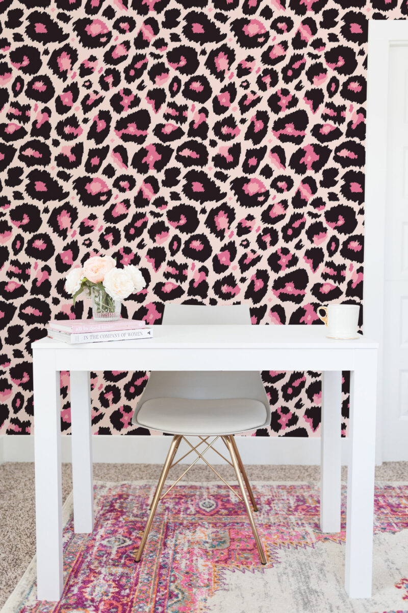 Bold Pink Leopard non-pasted wallpaper with black and pink leopard spots covering a wall behind a white desk.