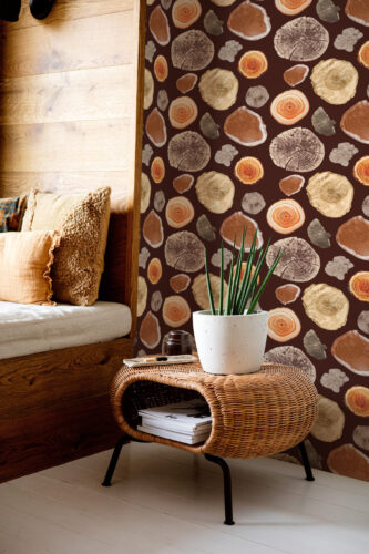 Bold Brown Wood Slice peel and stick wallpaper with scattered log cross-sections creates a warm accent wall behind a side table.
